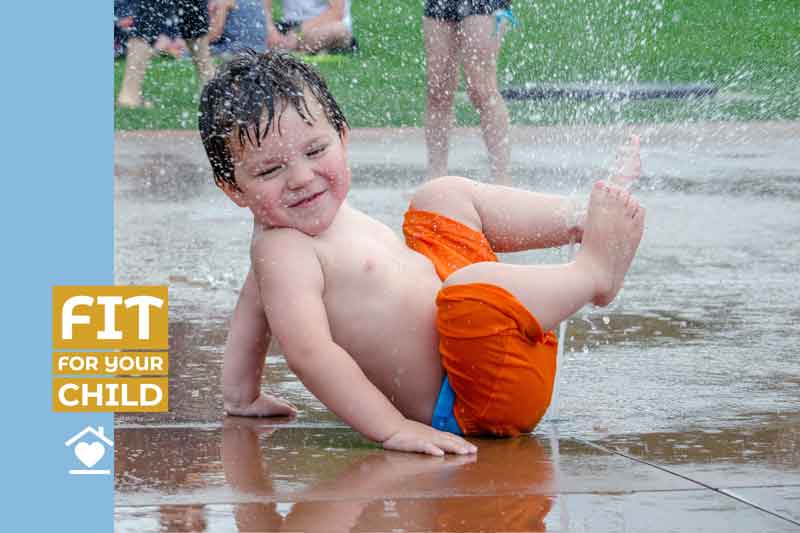 Child with feet in sprinkler